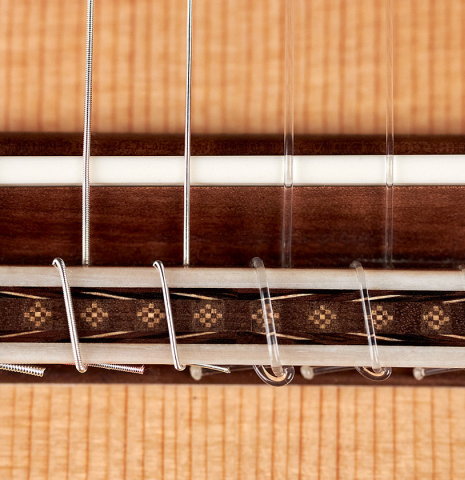 The bridge, saddle and tie block of a 2022 Sebastian Stenzel classical guitar made of spruce and CSA rosewood