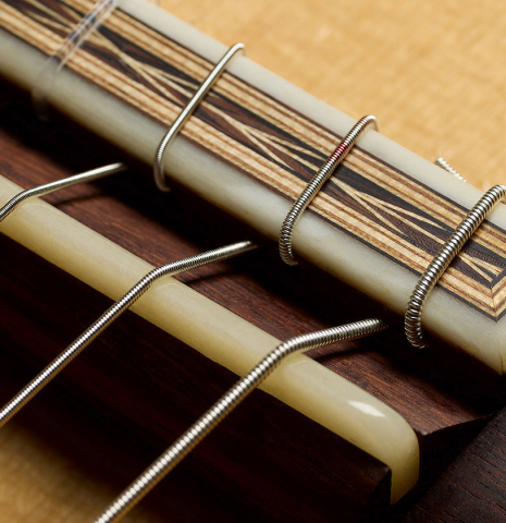 The bridge, tie-block and saddle of a 2010 Sebastian Stenzel classical guitar made of spruce and African rosewood