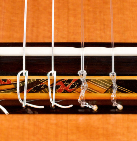 The bridge and saddle of a 2022 Giovanni Tacchi classical guitar Friederich model made of cedar and Indian rosewood