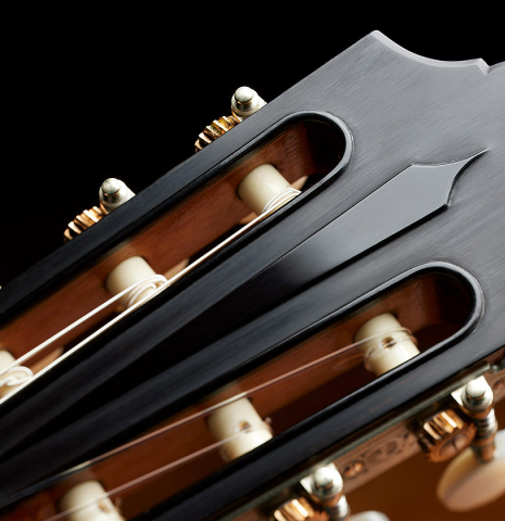 The headstock with carved relief of a 2024 Giovanni Tacchi classical guitar Friederich model made of cedar and Indian rosewood