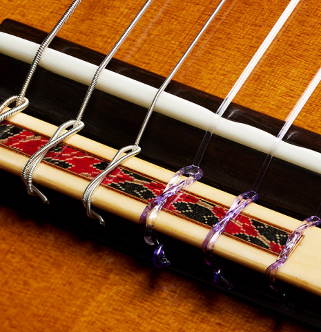 The bridge, tie-block and saddle of a 2024 Giovanni Tacchi classical guitar Friederich model made of cedar and Indian rosewood