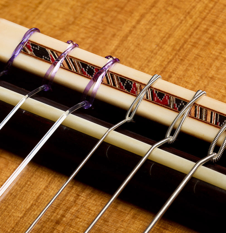 The bridge, tie-block and saddle of a 2026 Giovanni Tacchi classical guitar made of cedar and Indian rosewood