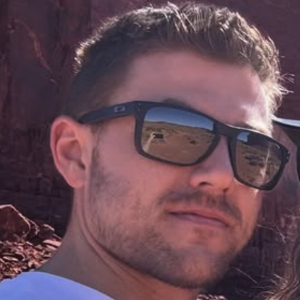 Giovanni Tacchi outdoors in sunglasses, red rock behind him