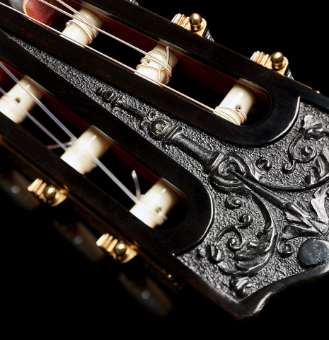 The carved headstock of a 2003 Andrea Tacchi &quot;Omaggio a Francisco Simplicio&quot; classical guitar made of spruce and satwinwood