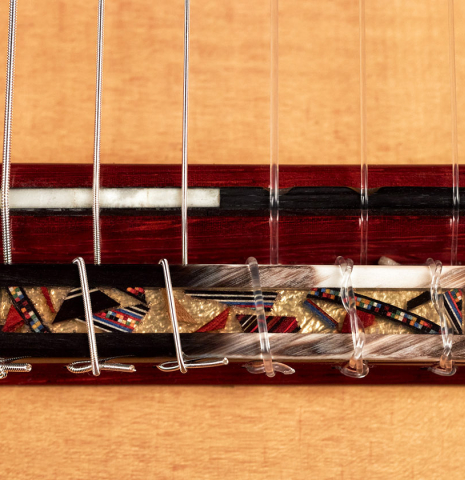 The ornamented tie block of a 2023 Andrea Tacchi "Coclea Thucea - Alter Ego" classical guitar.