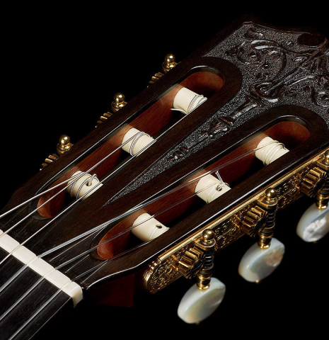 The carved headstock and tuning machines of a 2006 Andrea Tacchi "Omaggio a Francisco Simplicio" classical guitar made of spruce and CSA rosewood