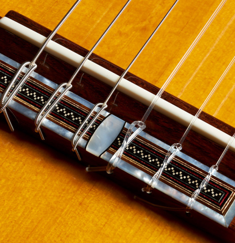 The bridge, tie-block and saddle of a 2006 Andrea Tacchi "Omaggio a Francisco Simplicio" classical guitar made of spruce and CSA rosewood
