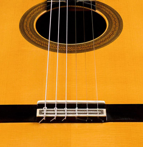 The bridge and saddle of a 2009 Mariano Tezanos "Maestro" classical guitar made with spruce and CSA rosewood