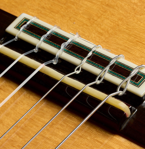 The bridge, tie-block and saddle of a 2010 Sergio Tezanos classical guitar made of spruce and maple