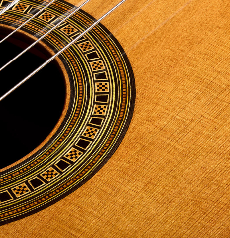 The soundboard and rosette of a 2018 Michael Thames classical guitar made of cedar and Indian rosewood