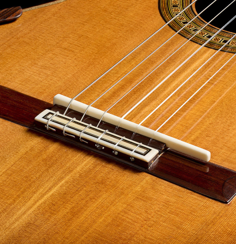 The bridge, tie-block and saddle of a 2018 Michael Thames classical guitar made of cedar and Indian rosewood