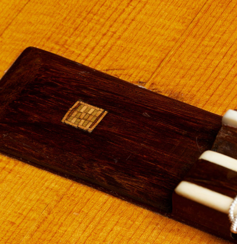 The bridge with inlay of a 1867 Antonio de Torres classical guitar made of spruce and maple