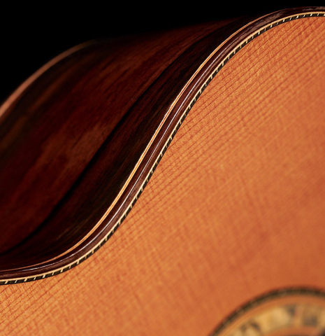 The soundboard and side of a 2016 Dake Traphagen made with cedar and CSA rosewood featuring traditional pegs.