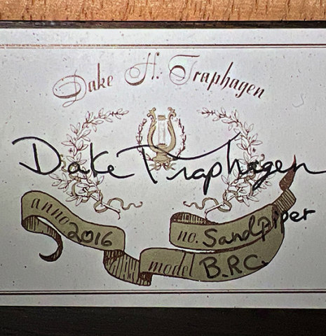 The label of a 2016 Dake Traphagen made with cedar and CSA rosewood featuring traditional pegs.