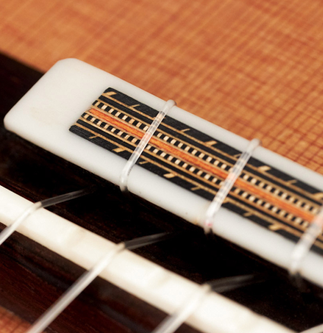 The tie block of a 2016 Dake Traphagen made with cedar and CSA rosewood featuring traditional pegs.