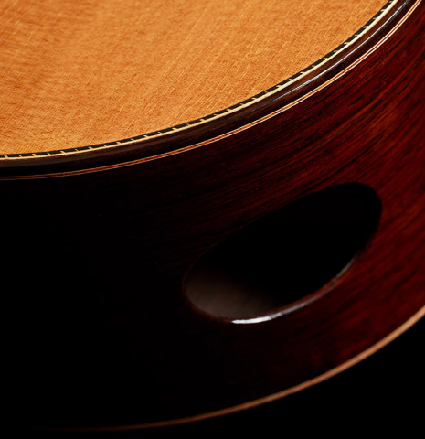 The side soundport of a 2023 Dake Traphagen classical guitar made of cedar and CSA rosewood