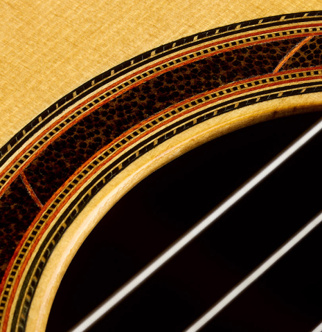 Closeup detail of the rosette of a 2005 Dake Traphagen classical guitar made of spruce and African rosewood