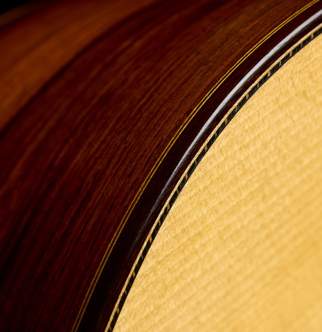 The soundboard purfling and side of a 2005 Dake Traphagen classical guitar made of spruce and African rosewood