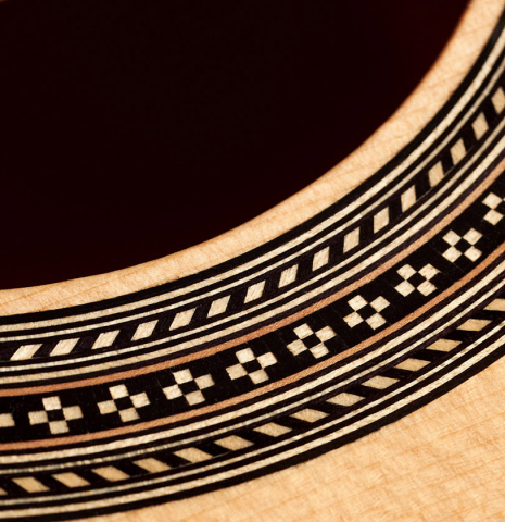 This is a close-up of the rosette of a 2020 Mark Usherovich w/pegs classical guitar made with spruce top and cypress back and sides