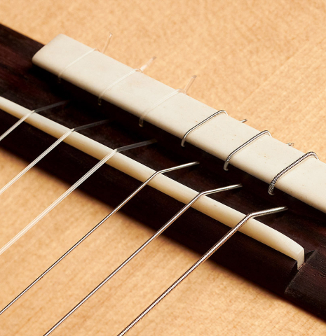 This is the bridge, tie-block and saddle of a 2020 Mark Usherovich w/pegs classical guitar made with spruce top and cypress back and sides