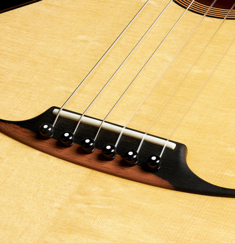 The bridge and saddle of a 2024 Mark Usherovich "Romantic" classical guitar made of spruce and maple