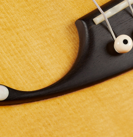 The bridge of a 2024 Mark Usherovich "Romantic" classical guitar made of spruce and maple