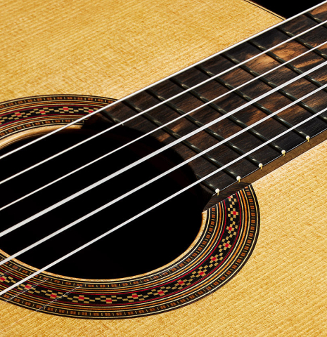 The soundboard of a 2023 Mark Usherovich "Lattice" classical guitar made of spruce and pau ferro