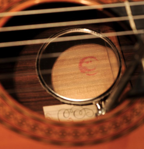 A smiley-face stamp on the underside of the top of a 1978 Manuel Velazquez classical guitar made of cedar and Indian rosewood