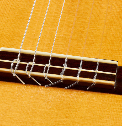 The bridge, tie-block and saddle of a 1955 Manuel Velazquez classical guitar made of spruce and CSA rosewood