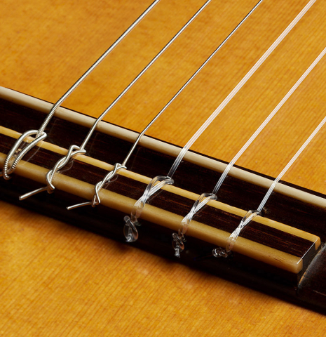 The bridge, tie-block and saddle of a 1960 Manuel Velazquez classical guitar made of spruce and CSA rosewood