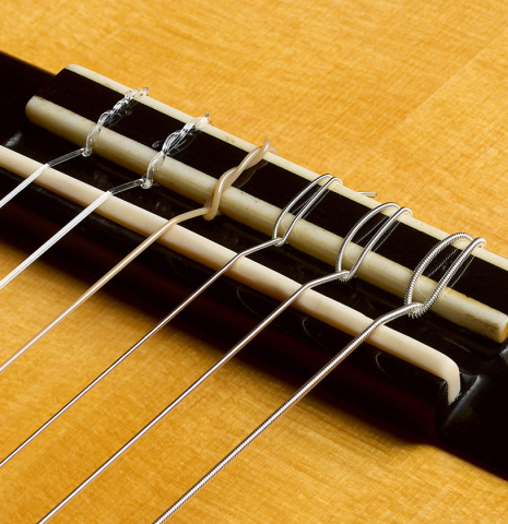 The bridge, tie-block and saddle of a 1996 Manuel Velazquez classical guitar made of spruce and CSA rosewood
