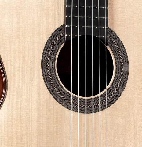 The soundboard and rosette of a 2023 Jose Vigil classical guitar made of spruce and CSA rosewood.