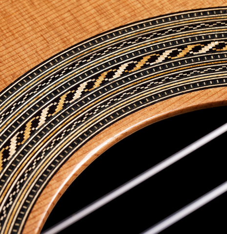 Closeup detail of the rosette of a 2024 Jose Vigil classical guitar made of cedar and CSA rosewood.