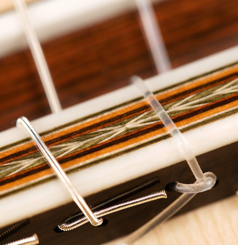 The bridge and saddle of a 2022 Otto Vowinkel classical guitar made with spruce soundboard and CSA rosewood.