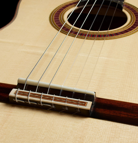 The bridge, tie-block and saddle of a 2025 Otto Vowinkel classical guitar made with spruce and cocobolo