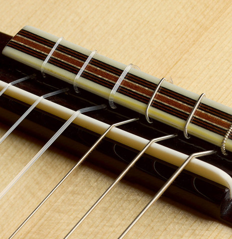 The bridge, tie-block and saddle of an Otto Vowinkel "2a" classical guitar made with spruce top and maple back and sides.