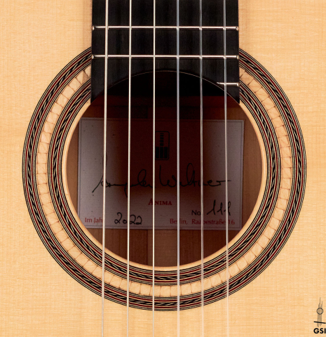 The rosette of a 2022 Angela Waltner classical guitar on a white background.