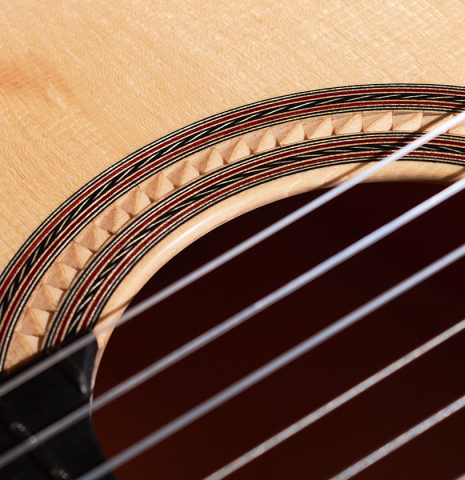 A detailed photo of the carved rosette of a 2022 Angela Waltner classical guitar.
