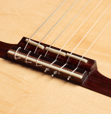 The adjustable saddle and bridge of a 2022 Angela Waltner classical guitar.