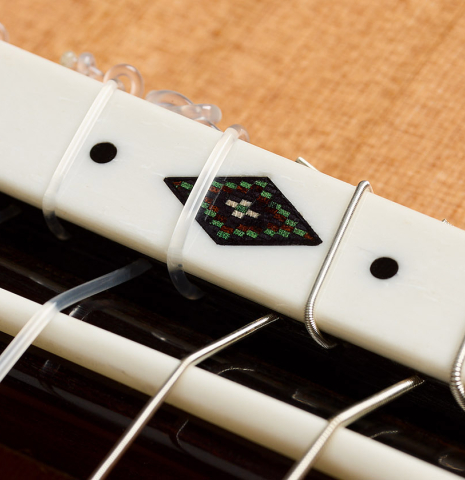 The tie-block with inlay, bridge and saddle of a 2025 Julia Wenzel classical guitar made of cedar and CSA rosewood