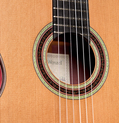 The soundboard and rosette of a 2022 Julia Wenzel classical guitar made of cedar and purpleheart wood
