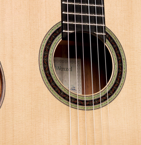 The soundboard and rosette of a 2022 Julia Wenzel classical guitar made of spruce and granadillo
