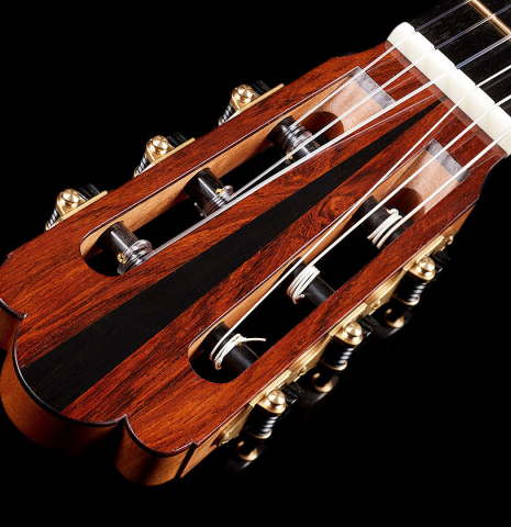 The headstock veneer and tuning machines of a 2024 Julia Wenzel classical guitar made of cedar and African rosewood