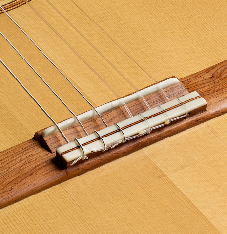 The bridge, tie-block and saddle of a 2023 Ken Whisler classical guitar made of spruce and Indian rosewood