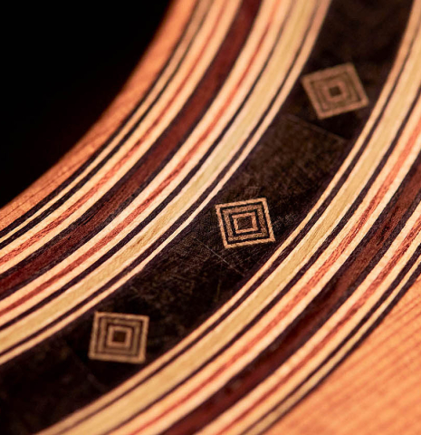 A close-up of the rosette of a 2022 Dominik Wurth classical guitar made with cedar and Indian rosewood