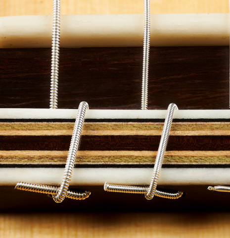 The bridge, tie-block and saddle of a 2023 Dominik Wurth classical guitar made of spruce and Indian rosewood