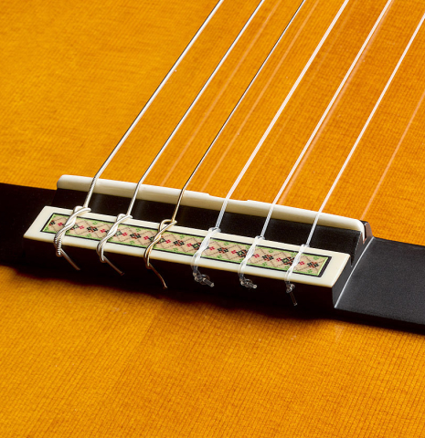 The bridge, tie-block and saddle of a 2025 Yamaha "Grand Concert GC22" classical guitar made of cedar and Indian rosewood