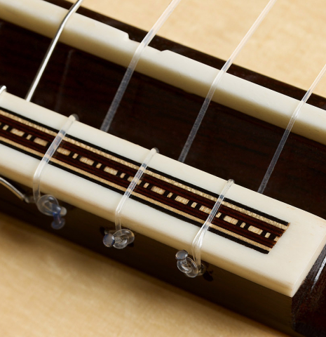 The bridge, tie-block and saddle of a 2026 Fructuoso Zalapa "Romanillos" classical guitar made of spruce and cocobolo