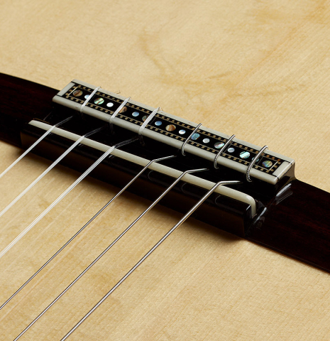 The bridge, tie-block and saddle of a 2024 Silvia Zanchi classical guitar made of spruce and Indian rosewood