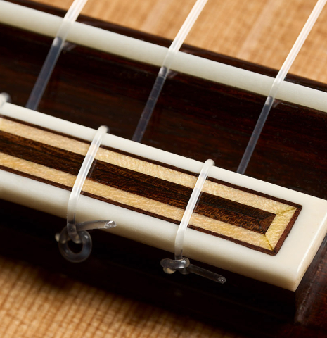 The bridge, tie-block and saddle of a 2025 Colin van Aelbrouck "Negra" flamenco guitar made of cedar and Indian rosewood